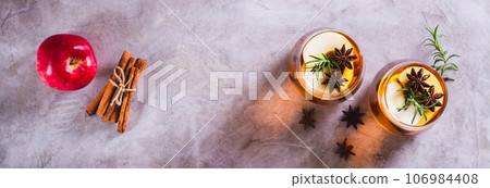 Apple margarita cocktail with cinnamon, anise and rosemary in glasses top view web banner 106984408