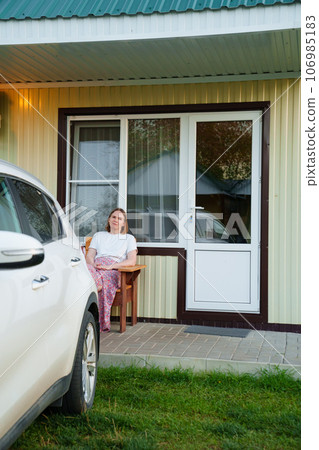 woman on the terrace with place to relax in fresh air in front of motel houses. woman on the terrace with place to relax in fresh air in front of motel houses. 106985183