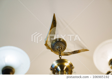 A torn stretch ceiling with a ceiling lamp A torn stretch ceiling with a ceiling lamp 106985192