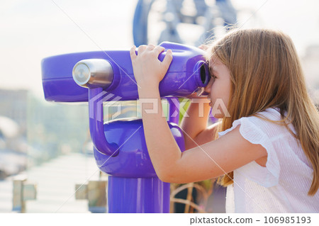 a teenage girl looks into the Binoscope from the observation deck at a height. a teenage girl looks into the Binoscope from the observation deck at a height. 106985193