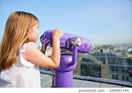 a teenage girl looks into the Binoscope from the observation deck at a height. a teenage girl looks into the Binoscope from the observation deck at a height. 106985194