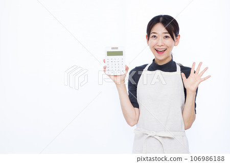 一位 30 多歲的家庭主婦拿著計算器，在白色背景前微笑，感到驚訝 106986188