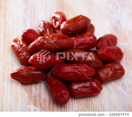 Spanish Chistoritas sausages on a wooden surface Spanish Chistoritas sausages on a wooden surface 106987474