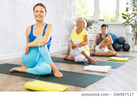 Group of people generation on mats doing yoga exercise lord of fishes pose. Group of people generation on mats doing yoga exercise lord of fishes pose. 106987517
