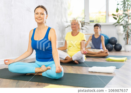 Family three generations do half lotus position Sidhasana with hands clasped in mudra of knowledge Family three generations do half lotus position Sidhasana with hands clasped in mudra of knowledge 106987637