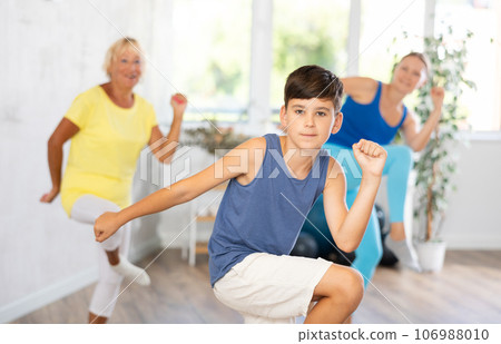 Happy preteen boy practicing dance positions during workout session 106988010