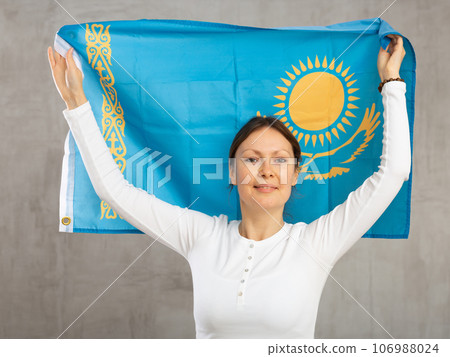 Happy smiling woman proudly displaying kazakh flag 106988024