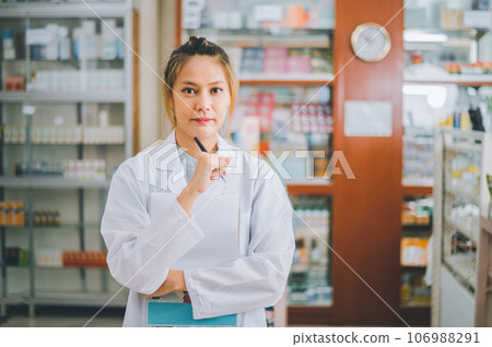 female pharmacist poses confidently welcoming, advising patients and prescription patients in a modern pharmacy. 106988291