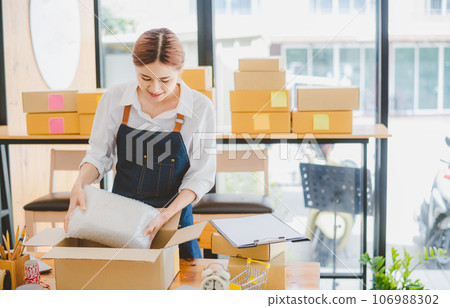 Online small business owners are packing their ordered products into the boxes for their customers based on the concept of online shopping - online shopping. Online small business owners are packing their ordered products into the boxes for their customers based on the concept of online shopping - online shopping. 106988302