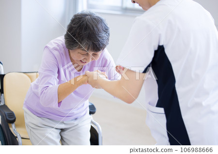 Medical care: Senior woman and physical therapist standing up from a wheelchair Photography cooperation: Chuo College of Technology Japanese Language School 106988666