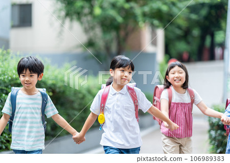 Elementary school students go to school with friends. 106989383