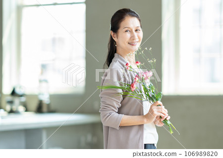senior woman with flowers 106989820