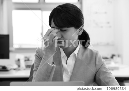 Monochrome image of a tired female office worker Monochrome image of a tired female office worker 106989884