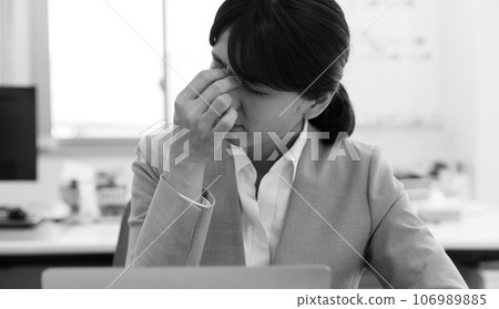Monochrome image of a tired female office worker 106989885