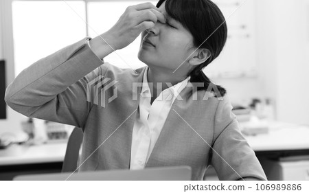 Monochrome image of a tired female office worker Monochrome image of a tired female office worker 106989886