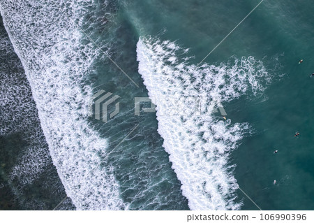 Amazing aerial view Top down of waves break on tropical sea Surfers with surfing boards Aerial drone view of sea waves on the beautiful sea surface ocean at Phuket Thailand. Amazing aerial view Top down of waves break on tropical sea Surfers with surfing boards Aerial drone view of sea waves on the beautiful sea surface ocean at Phuket Thailand. 106990396