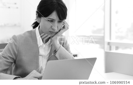一位女上班族在電腦前擔心/困擾的單色圖像 106990554