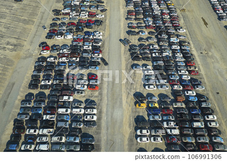 View from above of big parking lot with parked used cars after accident ready for sale. Auction reseller company selling secondhand broken vehicles for repair View from above of big parking lot with parked used cars after accident ready for sale. Auction reseller company selling secondhand broken vehicles for repair 106991306