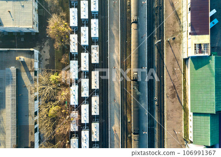 Top down aerial view of many cargo train cars on railway tracks. Top down aerial view of many cargo train cars on railway tracks. 106991367