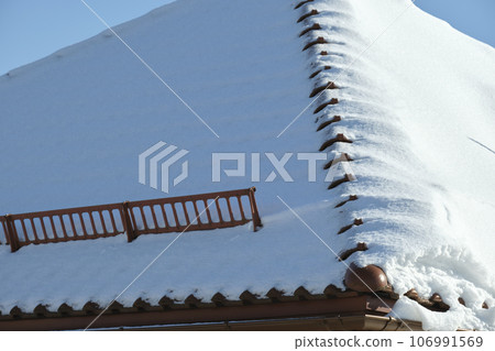 Snow guard for safety in winter on house roof top covered with steel shingles. Tiled covering of building 106991569
