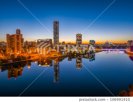 Yekaterinburg city and pond aerial panoramic view at summer or early autumn night. Night city in the early autumn or summer. Yekaterinburg city and pond aerial panoramic view at summer or early autumn night. Night city in the early autumn or summer. 106991910