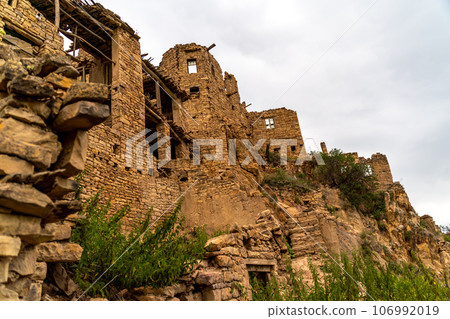 Dagestan Gamsutl. Ancient ghost town of Gamsutl old stone houses in abandoned Gamsutl mountain village in Dagestan, Abandoned etnic aul, summer landscape. 106992019