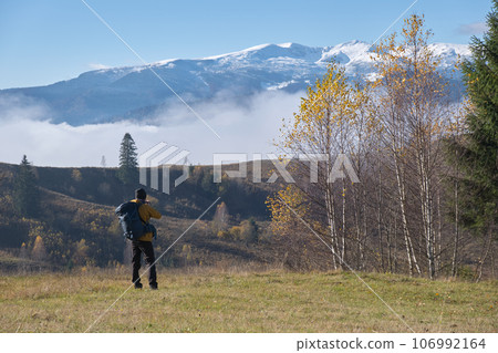 Photographer hiker taking picture of nature with digital camera 106992164