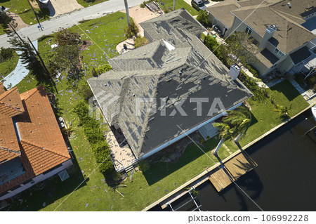 Hurricane Ian destroyed house roof in Florida residential area. Natural disaster and its consequences Hurricane Ian destroyed house roof in Florida residential area. Natural disaster and its consequences 106992228