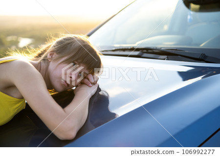 Happy woman driver in summer dress enjoying warm evening near her car. Travel and vacation concept. Happy woman driver in summer dress enjoying warm evening near her car. Travel and vacation concept. 106992277