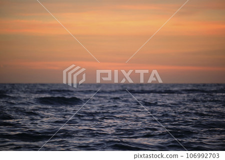 Dramatic red ocean waves at sunset with soft evening sea dark water Dramatic red ocean waves at sunset with soft evening sea dark water 106992703