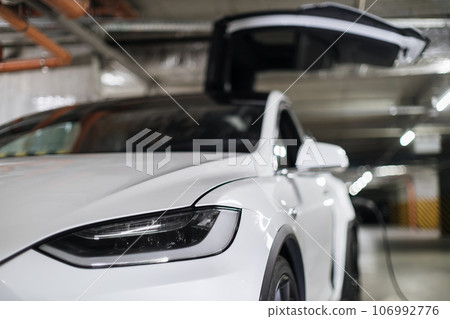 EV being parked with open wing door in charging session EV being parked with open wing door in charging session 106992776