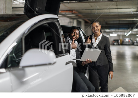 Coworkers discussing issues via laptop in EV in basement Coworkers discussing issues via laptop in EV in basement 106992807