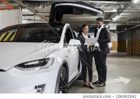 Electric vehicle with open scissor doors near work mates Electric vehicle with open scissor doors near work mates 106992842
