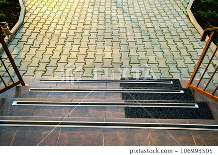 Closeup of ceramic tiles covering porch stairs with rubber anti slippery stripes on it. Closeup of ceramic tiles covering porch stairs with rubber anti slippery stripes on it. 106993505