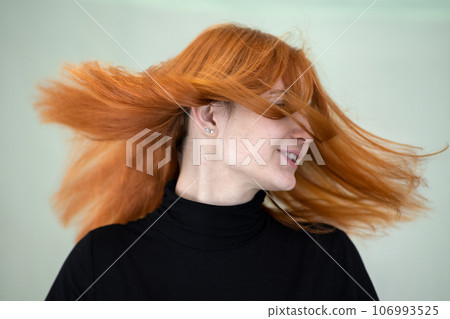 Close up portrait of pretty redhead girl with long wavy hair blowing on the wind. Close up portrait of pretty redhead girl with long wavy hair blowing on the wind. 106993525