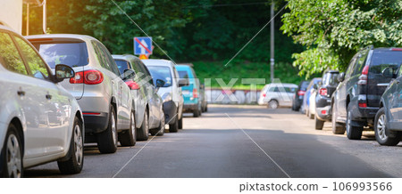 City traffic with cars parked in line on street side. City traffic with cars parked in line on street side. 106993566