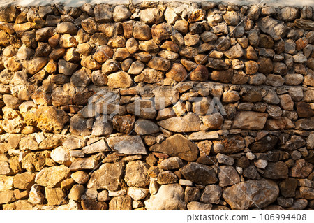 Sturdy yellow and beige cut stone wall made in Datca, Turkey, seamless lined up Sturdy yellow and beige cut stone wall made in Datca, Turkey, seamless lined up 106994408