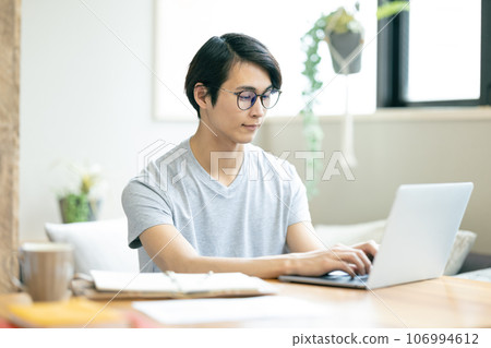 A man who works on a personal computer 106994612