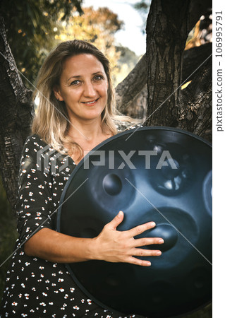 Portrait of a woman with a handpan her hands 106995791