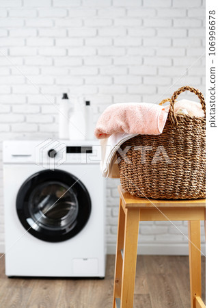 Laundry room with washing machine and basket with laundry 106996678