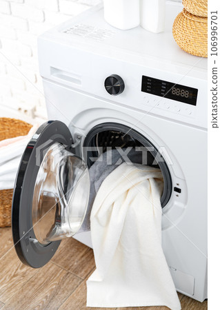 Washing machine and basket in a laundry room Washing machine and basket in a laundry room 106996701