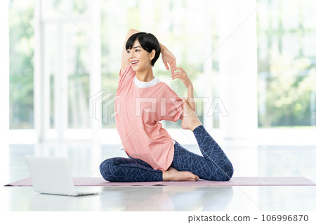 A woman doing online yoga. 106996870