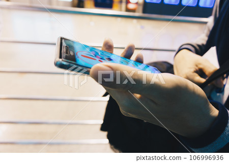 Man hand use smartphone in airport background Man hand use smartphone in airport background 106996936
