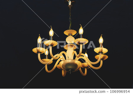 Yellow chandelier with candle lamps isolated on black 106996954