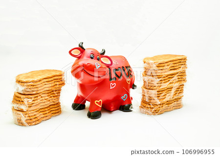 Delicious cookies packed in cellophane, a piggy bank as a cow, inscription love 106996955