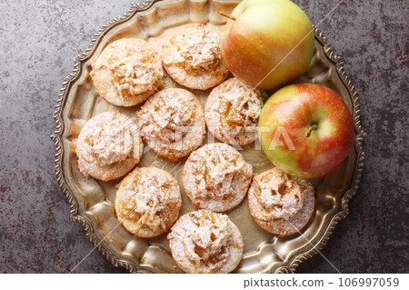 Cookies topped with apple jam and sprinkled with powdered sugar close-up in a plate. Horizontal top vew 106997059