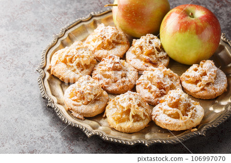 Homemade cookies with apple jam sprinkled with powdered sugar close-up in a plate. Horizontal Homemade cookies with apple jam sprinkled with powdered sugar close-up in a plate. Horizontal 106997070