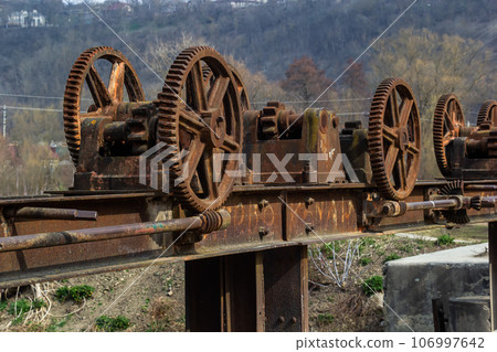 old mechanical metal gears mechanism on the abandoned dam 106997642