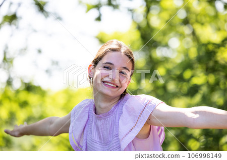 Radiant Laughter: Young Millennial Woman's Joyful Forest Portrait 106998149