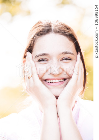 Radiant Joy: Happy Young Woman Embracing Life 106998154